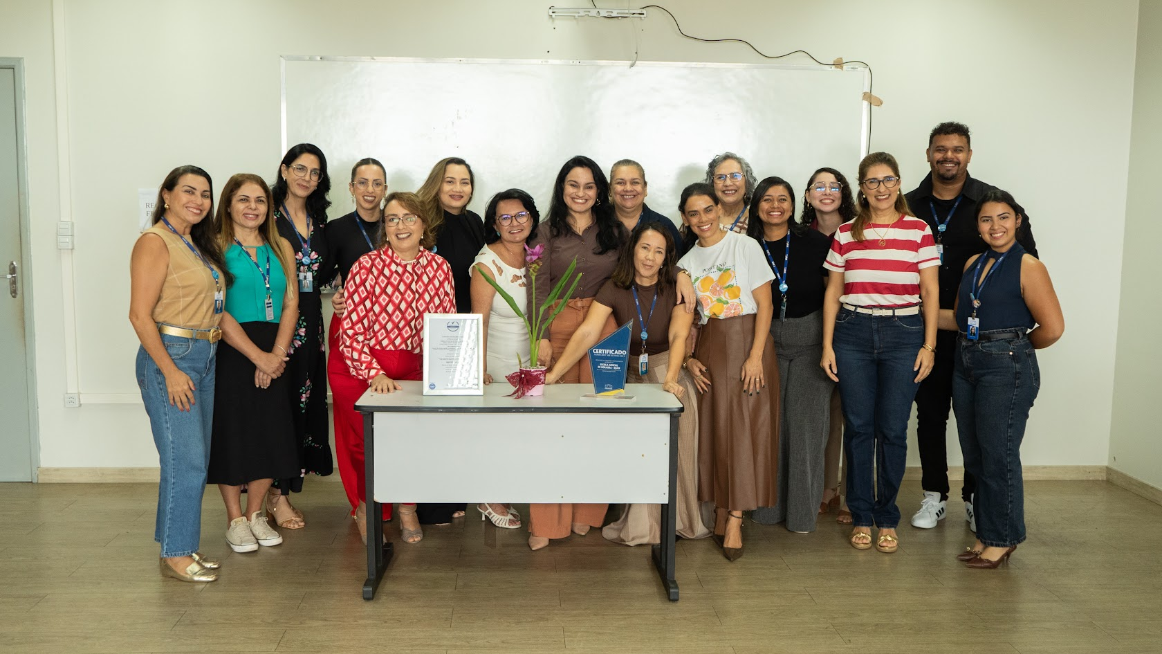 Um grupo de pessoas, dentre eles, homens e mulheres estão posando para o observador.
