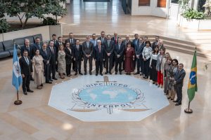 A imagem mostra um grupo de homens e mulheres reunidos em formato circular. No chão, Em frente no chão,