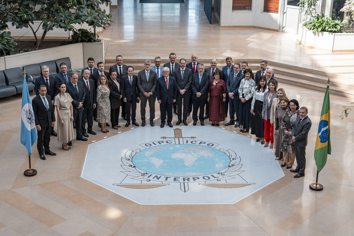 A imagem mostra um grupo de homens e mulheres reunidos em formato circular. No chão, Em frente no chão,