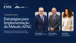Card digital na cor azul marinho com as logos da Escola Nacional da Magistratura e da Ejurr no topo superior esquerdo. Em destaque, o tútulo do seminário "estratégias para implementação do método APAC" e as fotos e nomes dos palestrantes, com suas funções abaixos. São eles: desembargador Nelson de Morais, diretor da ENM. Ele é um homem branco, calvo, usa óculos, sorri levemente, e veste terno azul marinho e gravata roxa. Em seguida, está o desembargador Caetano Levi Lopes, secretário geral da ENM. Ele é um homem pardo, calvo, sorri discretamente, veste terno cinza, blusa de listras azul e branco e gravata na cor cinza. À direita, está a diretora da Fraternidade Brasileira de Assistência aos Condenados, Tatiama Flávia Faria de Souza. Ela é uma mulher parda, cabelos cacheados com mechas douradas, sorri, usa colar com pingente prateado, terno nude e blusa branca, e está com as mãos no bolso.